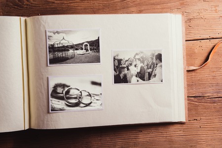 Wedding photos in album. Studio shot on wooden background.の写真素材