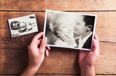 Wedding photos laid on a table. Studio shot on wooden background.の写真素材