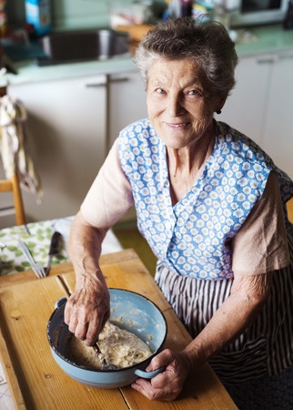 Senior woman baking pies in her home kitchen.  Kneading dough.の写真素材