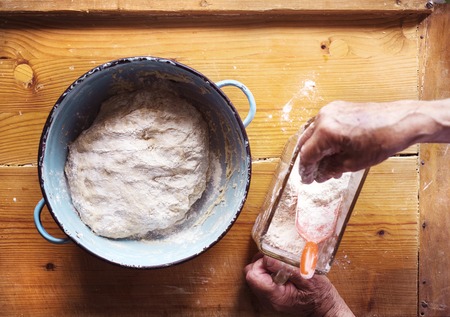 Senior woman baking pies in her home kitchen. Letting yeast dough stand to riseの写真素材
