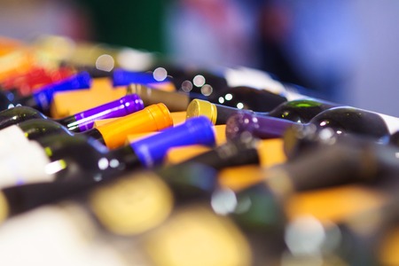 Various wine bottles in row on wooden shelf.の写真素材