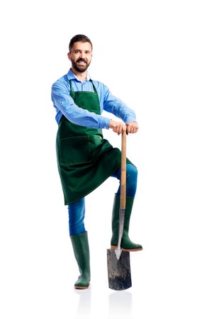Young handsome gardener in green apron. Studio shot on white backgroundの写真素材