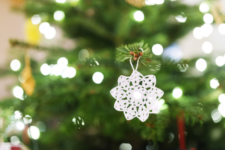 Close up of a white crocheted decoration hang on Christmas treeの写真素材
