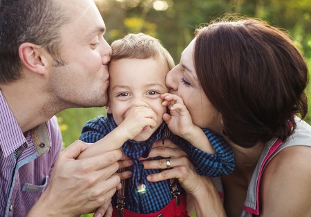 Happy young family having fun outside in summer nature