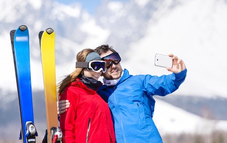 Young couple skiing outside in sunny winter mountainsの写真素材