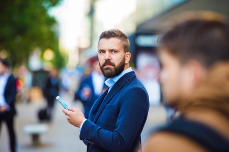 Handsome young manager with smartphone in London