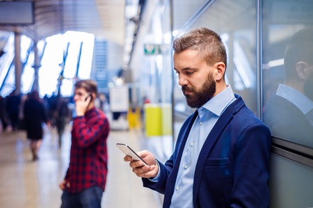 Young handsome businessman with tablet in subway