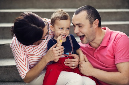 Happy young family having fun outside in summer natureの写真素材
