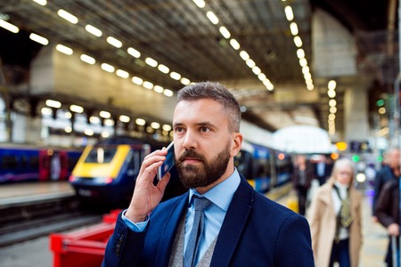Young handsome businessman with smart phone in subwayの写真素材