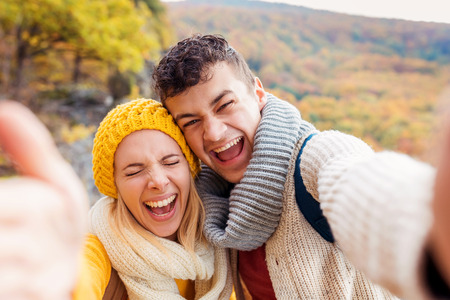 Beautiful young couple on a walk in autumn forestの写真素材
