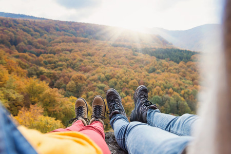 Unrecognizable young couple on a hike in autumn forestの写真素材