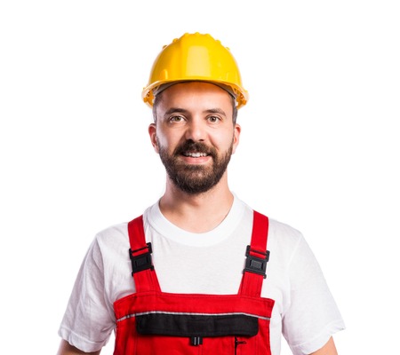 Young handsome worker in red overalls. Studio shot on white backgroundの写真素材