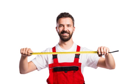 Young handsome worker in red overalls. Studio shot on white backgroundの写真素材