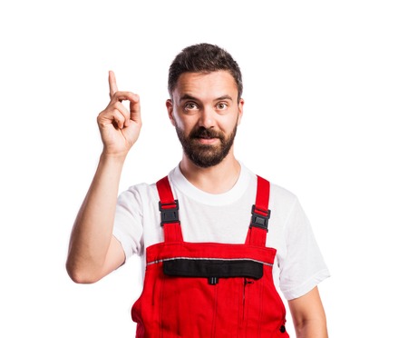 Young handsome worker in red overalls. Studio shot on white backgroundの写真素材