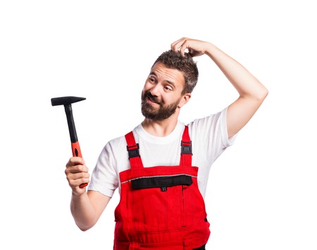 Young handsome worker in red overalls. Studio shot on white backgroundの写真素材