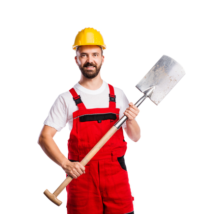 Young handsome worker in red overalls. Studio shot on white backgroundの写真素材