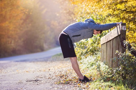 Young runner warming up and stretching on a bridgeの写真素材
