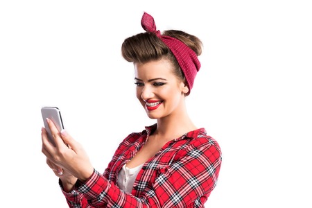 Beautiful young woman with pin-up make-up and hairstyle. Studio shot on white background