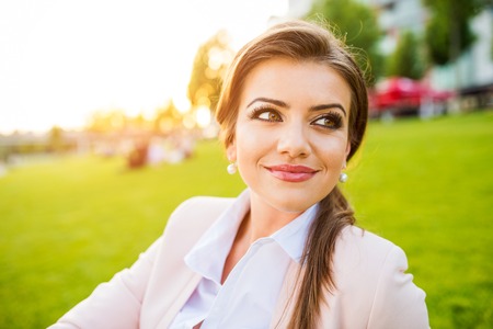 Beautiful young business woman sitting in a parkの写真素材