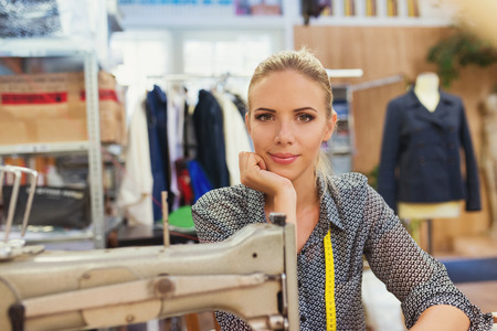Beautiful young woman with her sewing machine.の写真素材