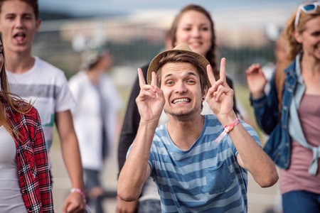 Handsome young boy with group of beautiful teens arriving at summer festivalの写真素材