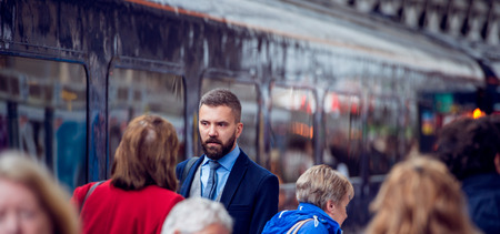 Hipster businessman walking at the station, crowded underground platform, trainの写真素材