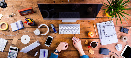 Business person working at office desk. Smart watch on hand and smart phone on the table. Coffee...