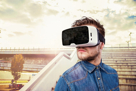 Hipster man in denim shirt wearing virtual reality goggles. Bratislava, Slovakia, New Bride.