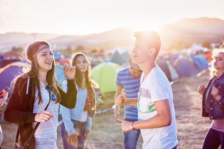 Group of teenage boys and girls at summer music festival, sunny dayの写真素材