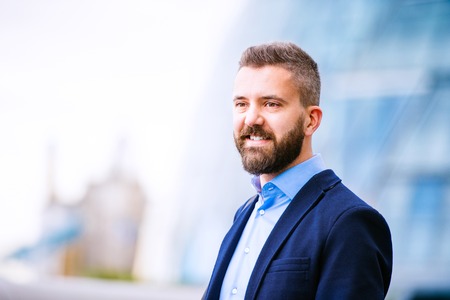 Hipster manager in blue shirt and jacket in the street of London, City Hallの写真素材