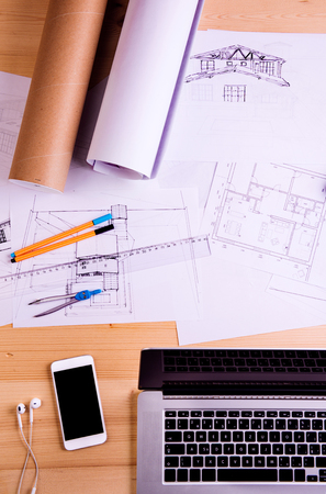 Desk with gadgets, office supplies and chart graph. Notebook, tablet, smart phone and stationery around the workplace. Flat lay. Studio shot on wooden background.の写真素材