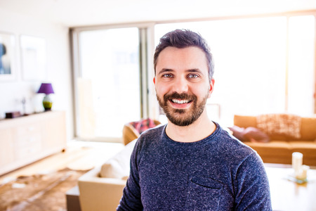 Handsome hipster businessman in blue long sleeved t-shirt, working from home, taking a break