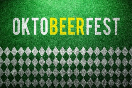 Oktoberfest sign with white and green rhombus pattern on artificial turf. Studio shot. Green background.の写真素材