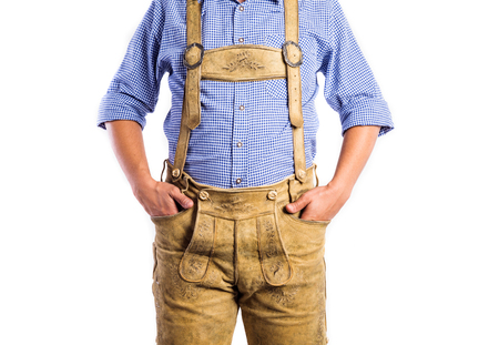 Unrecognizable man in traditional bavarian clothes, hands in pockets. Oktoberfest. Studio shot on white background, isolated.の写真素材