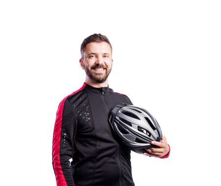Hipster man in sports sweatshirt holding helmet in his hand, studio shot white background, isolated.の写真素材