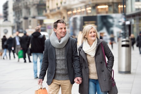 Beautiful senior couple shopping in historical centre of the city of Vienna, Austria. Winter.の写真素材