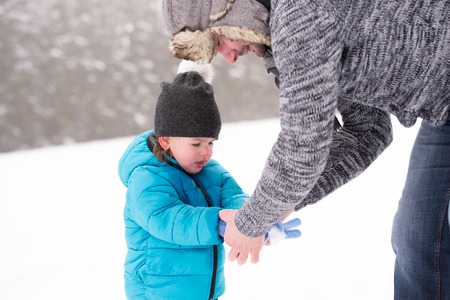 Young father having fun with his son, playing in the snow. Foggy white winter nature.の写真素材