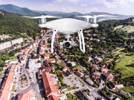 Hovering drone taking pictures of small town with many hills and forest surrounding it. Slovakia, Nova Bana. Aerial view.の写真素材