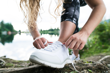 Close up of an unrecognizable young runner tying shoelacesの写真素材
