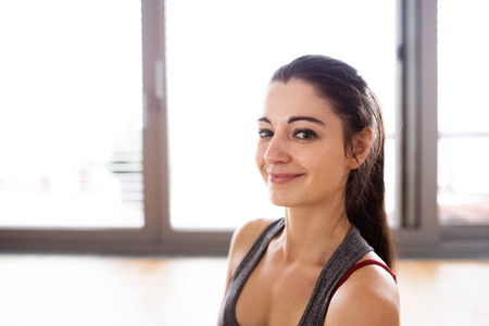 Young woman exercising at home, doing stretching.の写真素材