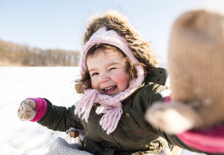 Cute little girl playing outside in winter natureの写真素材