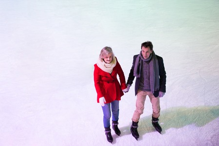 Beautiful senior couple ice skating in city centre. Winter