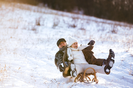 Beautiful senior couple on sledge having fun, winter day.の写真素材