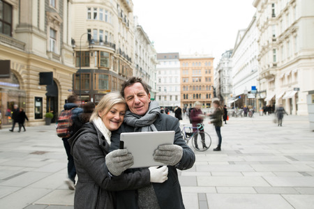 Beautiful senior couple on a walk in city centre taking selfie.の写真素材