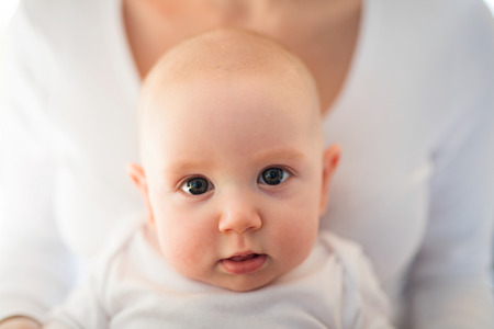Unrecognizable mother holding her cute baby son