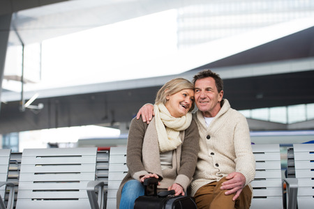 Beautiful senior couple waiting on train station, huggingの写真素材