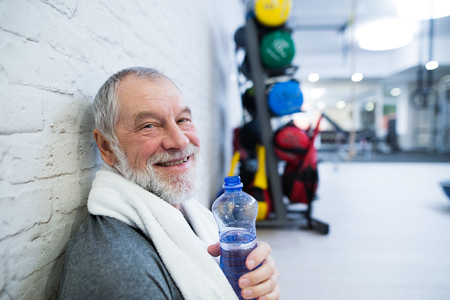 Fit senior man in gym resting after working out.の写真素材