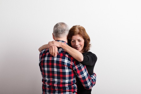 Beautiful senior couple in love hugging. Studio shot.の写真素材
