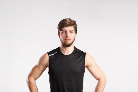 Handsome fitness man in black sleeveless shirt, studio shot.の写真素材