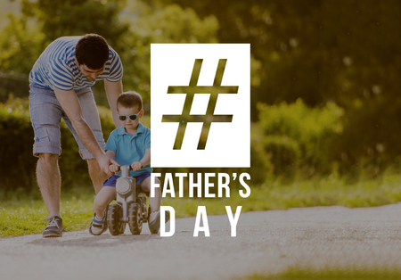 Father and son riding bike outdoors. Fathers day concept.の写真素材